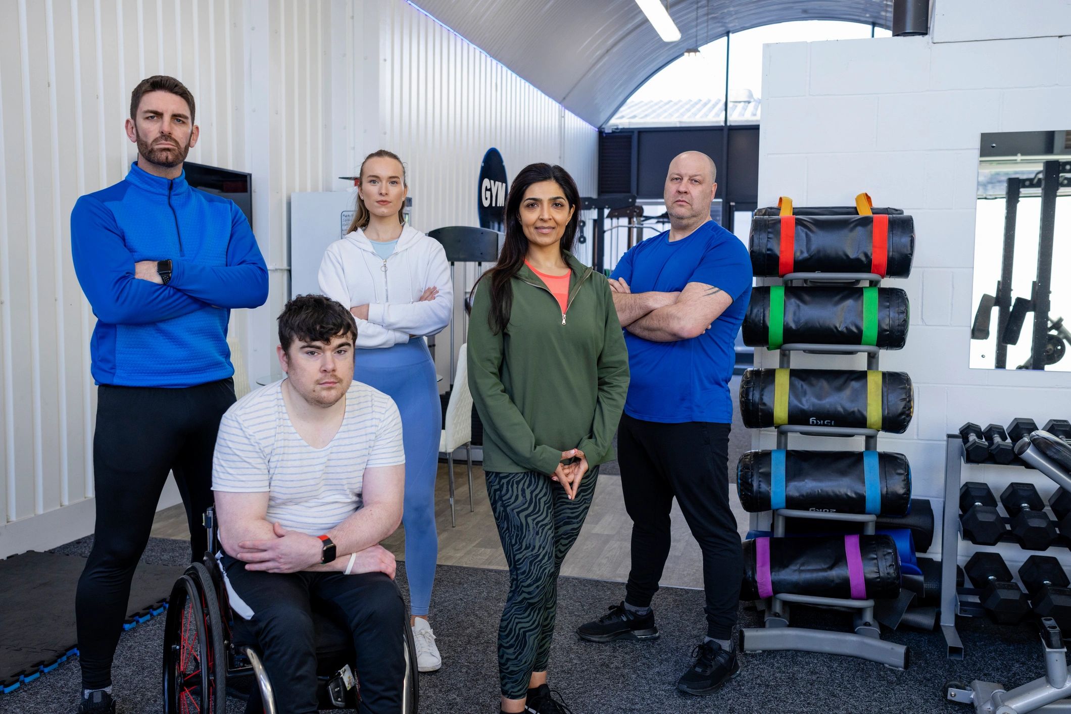 Welcoming fitness team and clients gathered together inside a modern studio